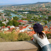 Young Female Tourist Admiring A View Of Narikala Fortress In Tbilisi, Georgia